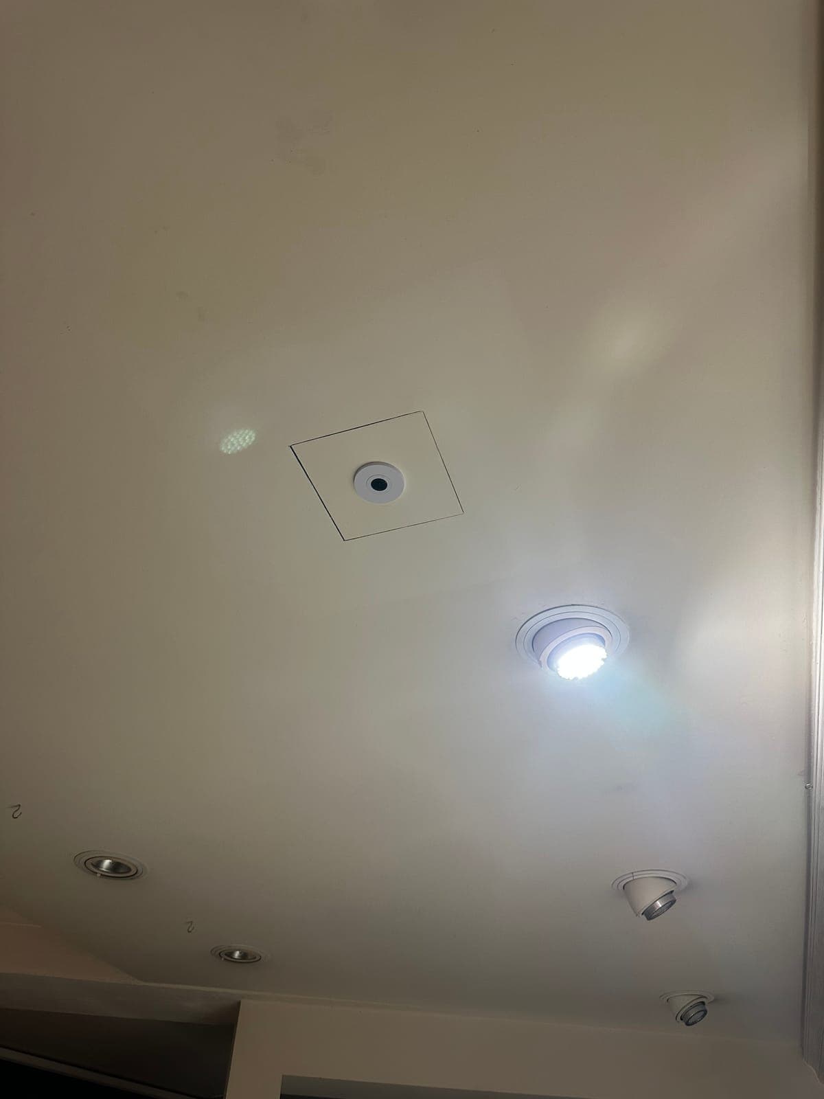 Bündig in die Decke eingelassene Überwachungskamera zwischen Einbauspots